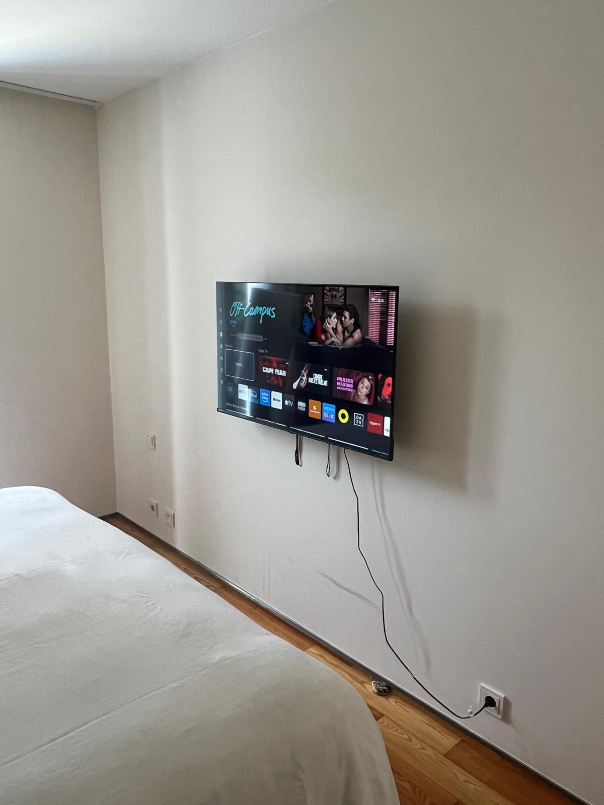 TV instalada em parede de quarto