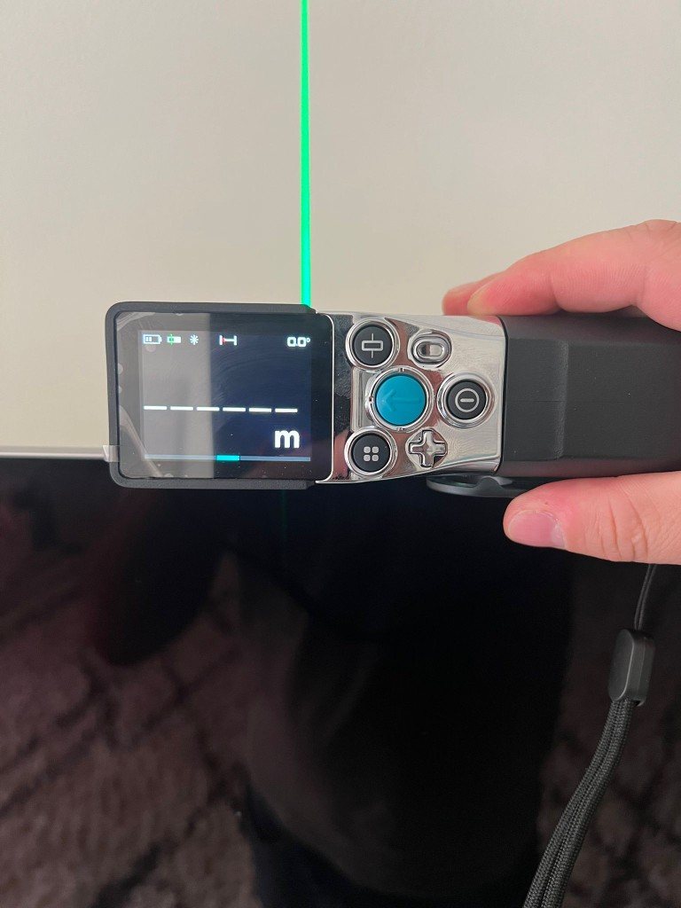 Verificação do nivelamento da televisão com nível digital a indicar 0,0 graus